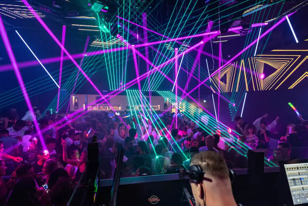 Une salle du Zip Club traversée par les lasers magenta et cyan au-dessus de la piste